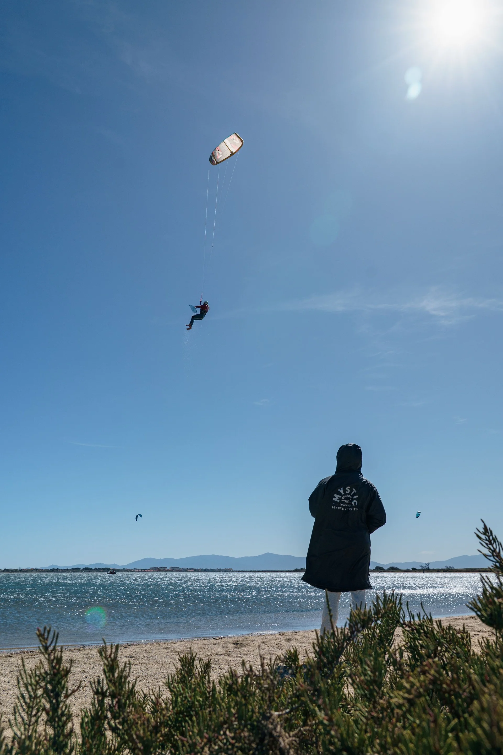 A kite rider soaring above the water during a coaching session